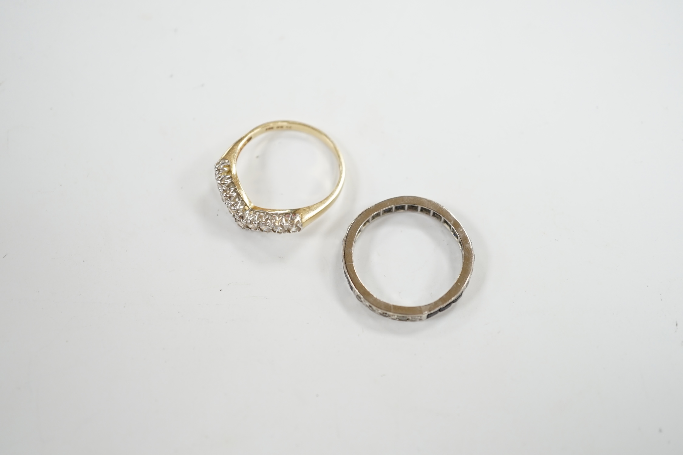 A white metal sapphire and diamond set full eternity ring, size Q/R, gross weight 3.6 grams, together with a 14k and cubic zirconia set chevron ring, gross 2.8 grams. Condition - fair to poor